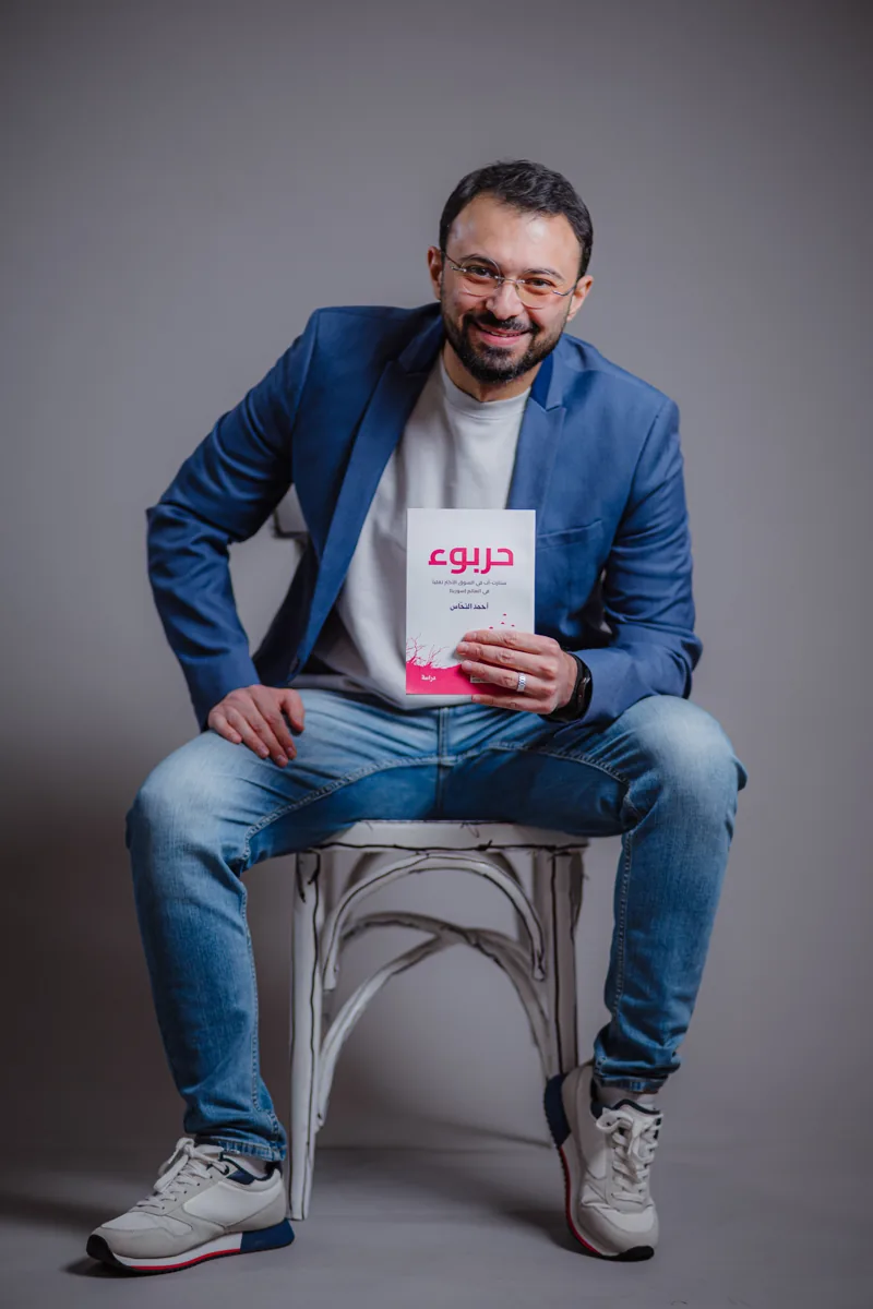 Ahmad Nahas seated holding the Harbuk book